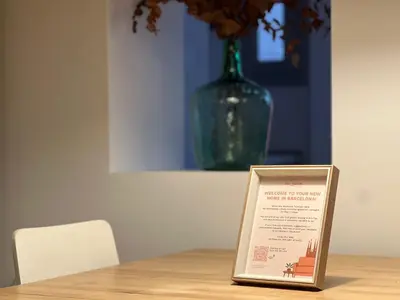 a sign sitting on top of a wooden table with a vase at Stay Unique Apartment Martínez de la Rosa in Barcelona