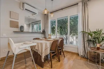 a dining room with a table and chairs and a window at NEW Refurbished Modern Apartment in Barcelona