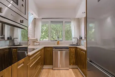 a kitchen with wooden cabinets and a large window at NEW Refurbished Modern Apartment in Barcelona