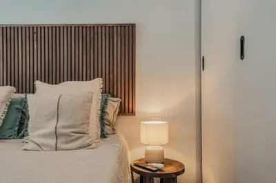 a bedroom with a bed and a table with a lamp at NEW Refurbished Modern Apartment in Barcelona