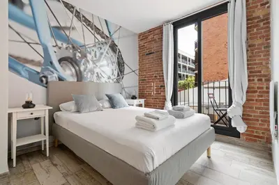 a bedroom with a bed with a large window at Sants Apartment in Barcelona