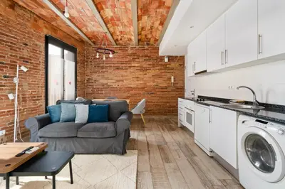 a living room with a couch and a brick wall at Sants Apartment in Barcelona