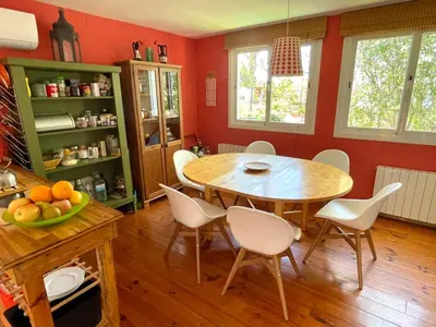 a kitchen with a table and chairs in a room at Casa familiar con piscina cerca del mar y montaña in San Pol de Mar