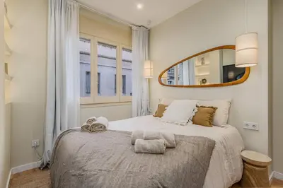 a bedroom with a large bed with a mirror on the wall at Bright Apartment in Barcelona in Barcelona
