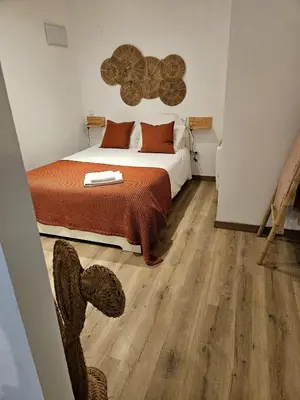 a bedroom with a bed and wooden floors at Poolside Apartment Barcelona Sant Cugat in Sant Cugat del Vallès