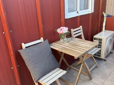 a table and chairs with a vase of flowers on it at Sunny Terrace Apartment in Santa Coloma de Gramanet