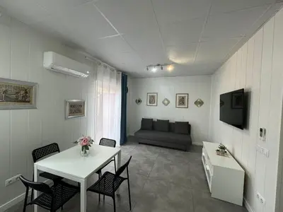 a living room with a table and chairs and a couch at Sunny Terrace Apartment in Santa Coloma de Gramanet