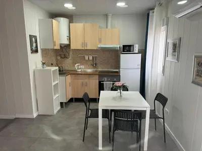 a kitchen with a table and a white table and chairs at Sunny Terrace Apartment in Santa Coloma de Gramanet