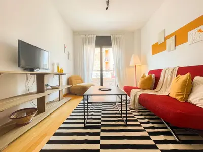 a living room with a red couch and a tv at Boutique Socors in Barcelona