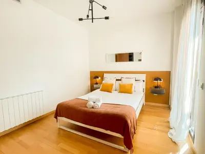 a bedroom with a large white bed with orange pillows at Boutique Socors in Barcelona