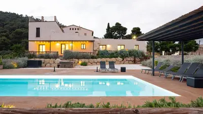 a villa with a swimming pool in front of a house at Masia Cal Noia - Rural Villas in Castellví de la Marca