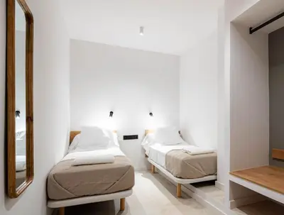 a bedroom with two beds and a mirror at Masia Cal Noia - Rural Villas in Castellví de la Marca