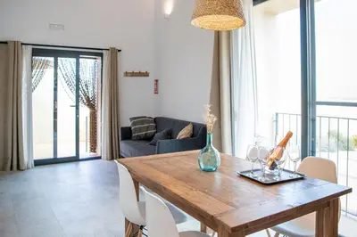 a living room with a wooden table and chairs at Masia Cal Noia - Rural Villas in Castellví de la Marca
