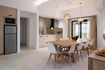 a kitchen and dining room with a wooden table and chairs at Masia Cal Noia - Rural Villas in Castellví de la Marca