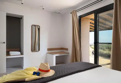 a bedroom with a bed with a hat and a window at Masia Cal Noia - Rural Villas in Castellví de la Marca