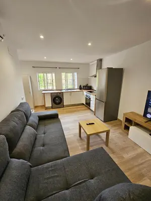 a living room with a couch and a kitchen at Confort House in Argentona