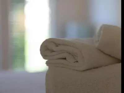 a stack of white towels sitting on top of a bed at Winahost Barcelona Gracia in Barcelona