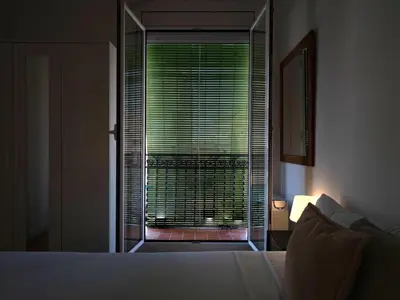 a bedroom with a bed and a window with blinds at Winahost Barcelona Gracia in Barcelona