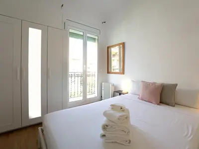 a bedroom with a white bed with towels on it at Winahost Barcelona Gracia in Barcelona