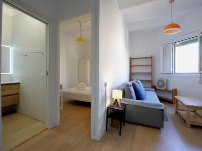 a living room with a bed and a bathroom at Winahost Barcelona Gracia in Barcelona