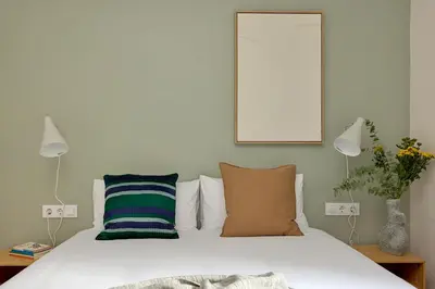 a bedroom with a bed and two lamps and a mirror at Casa Cosi - Camp Nou in Barcelona