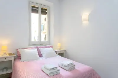 a white bedroom with a pink bed with towels on it at Tranquil Cozy with balcony Plaça Catalunya. RI. in Barcelona