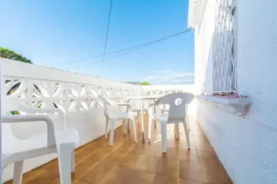 a balcony with white chairs and tables on a white wall at Mediterranean heaven with sea views in Alella