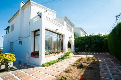 a white house with flowers in a yard at Mediterranean heaven with sea views in Alella
