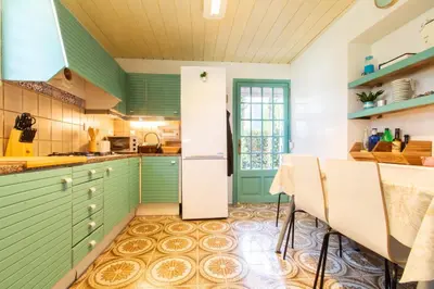 a kitchen with green cabinets and a table at Mediterranean heaven with sea views in Alella