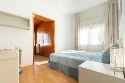 a bedroom with a bed and a window and a wooden floor at Mediterranean heaven with sea views in Alella