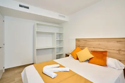 a bedroom with a bed with orange and white pillows at Tr3sor 11 in Calella