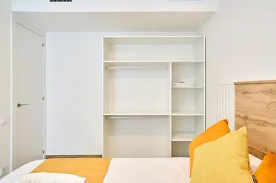 a bedroom with white shelves and a bed at Tr3sor 11 in Calella