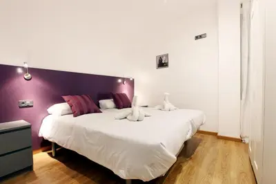 a large white bed with two stuffed animals on it at Apartment Park&Beach Deluxe in Barcelona