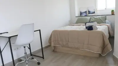 a bedroom with a bed with a desk and a chair at El Barco Aparta Hotel in Hospitalet de Llobregat