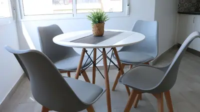 a table with four chairs and a plant on it at El Barco Aparta Hotel in Hospitalet de Llobregat
