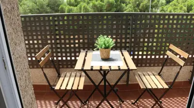 a table and chairs on a balcony with a potted plant at El Barco Aparta Hotel in Hospitalet de Llobregat