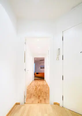 a hallway with white walls and a wooden floor at Apartment Gaudi XL in Barcelona