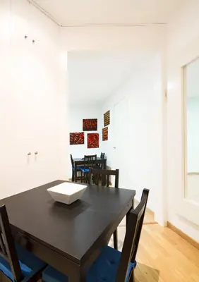 a dining room with a black table and chairs at Apartment Gaudi XL in Barcelona