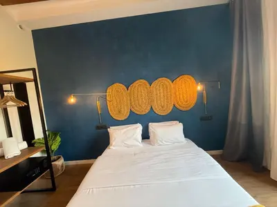 a bedroom with a large white bed with a blue wall at Vaganto Coliving in Barcelona