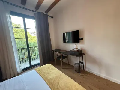 a bedroom with a bed and a tv and a window at Vaganto Coliving in Barcelona