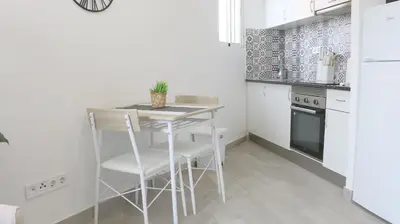 a kitchen with a small white table and chairs at Apartament Hotel - El Barco in Hospitalet de Llobregat