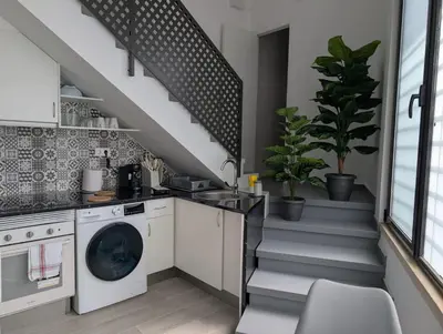 a kitchen with a washing machine and a staircase at Apartament Hotel - El Barco in Hospitalet de Llobregat