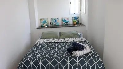 a bedroom with a bed with two towels on it at Apartament Hotel - El Barco in Hospitalet de Llobregat