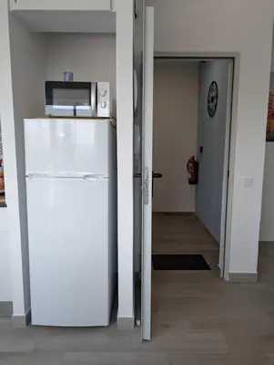 a kitchen with a refrigerator and a microwave at Apartament Hotel - El Barco in Hospitalet de Llobregat