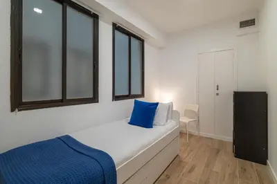 a bedroom with a bed with a blue pillow on it at Stay Unique Apartment Taquigraf in Barcelona