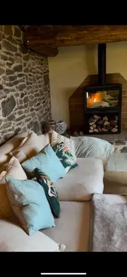 a group of people laying on pillows in a room with a fireplace at Roca negra Montseny in Fogars de Montclus