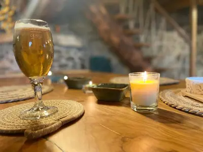 a glass of beer and a candle on a table at Roca negra Montseny in Fogars de Montclus