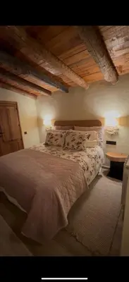 a bedroom with a large bed with white sheets and pillows at Roca negra Montseny in Fogars de Montclus