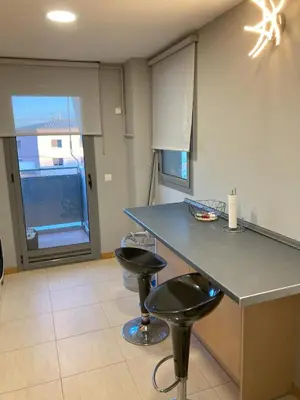 a kitchen with two bar stools and a counter at Fantastic apartment in Barberà in Barbera del Valles