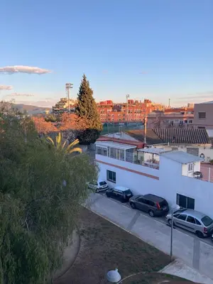 a building with two cars parked in a parking lot at Fantastic apartment in Barberà in Barbera del Valles